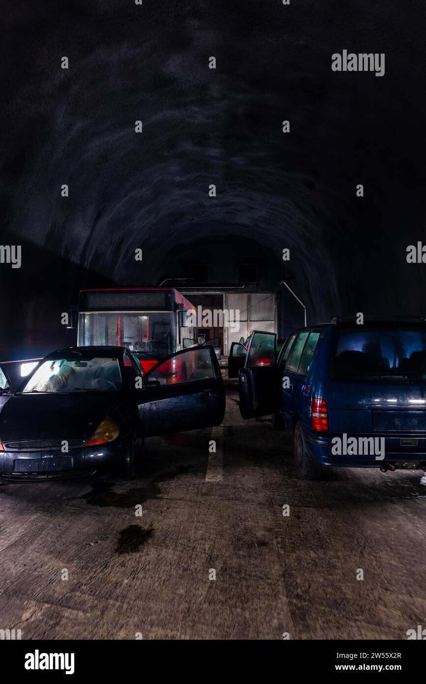 Dirty and Damaged Vehicles Inside a Mountain Road Tunnel in Switzerland Stock Photo