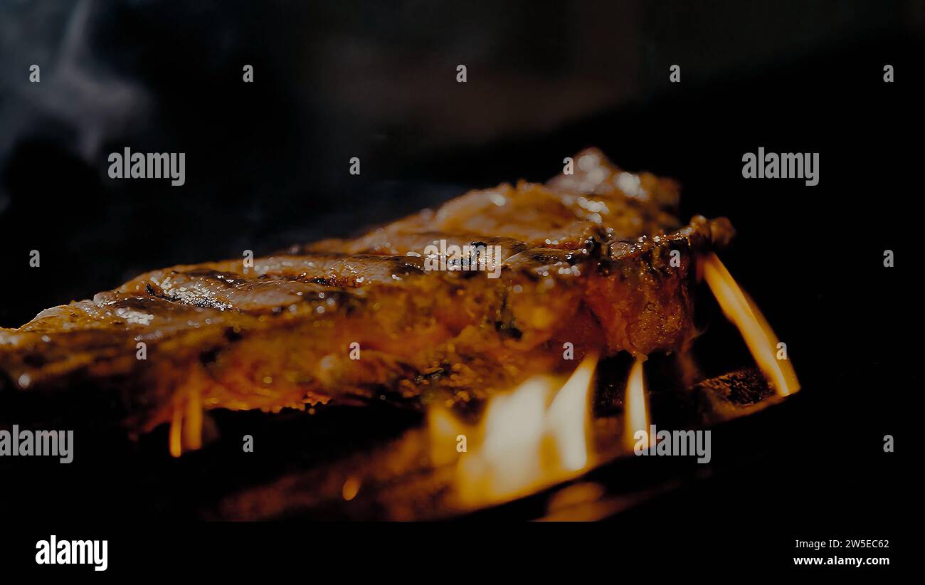 Beef cooked on the grill. Court entrails with flames of fire Stock