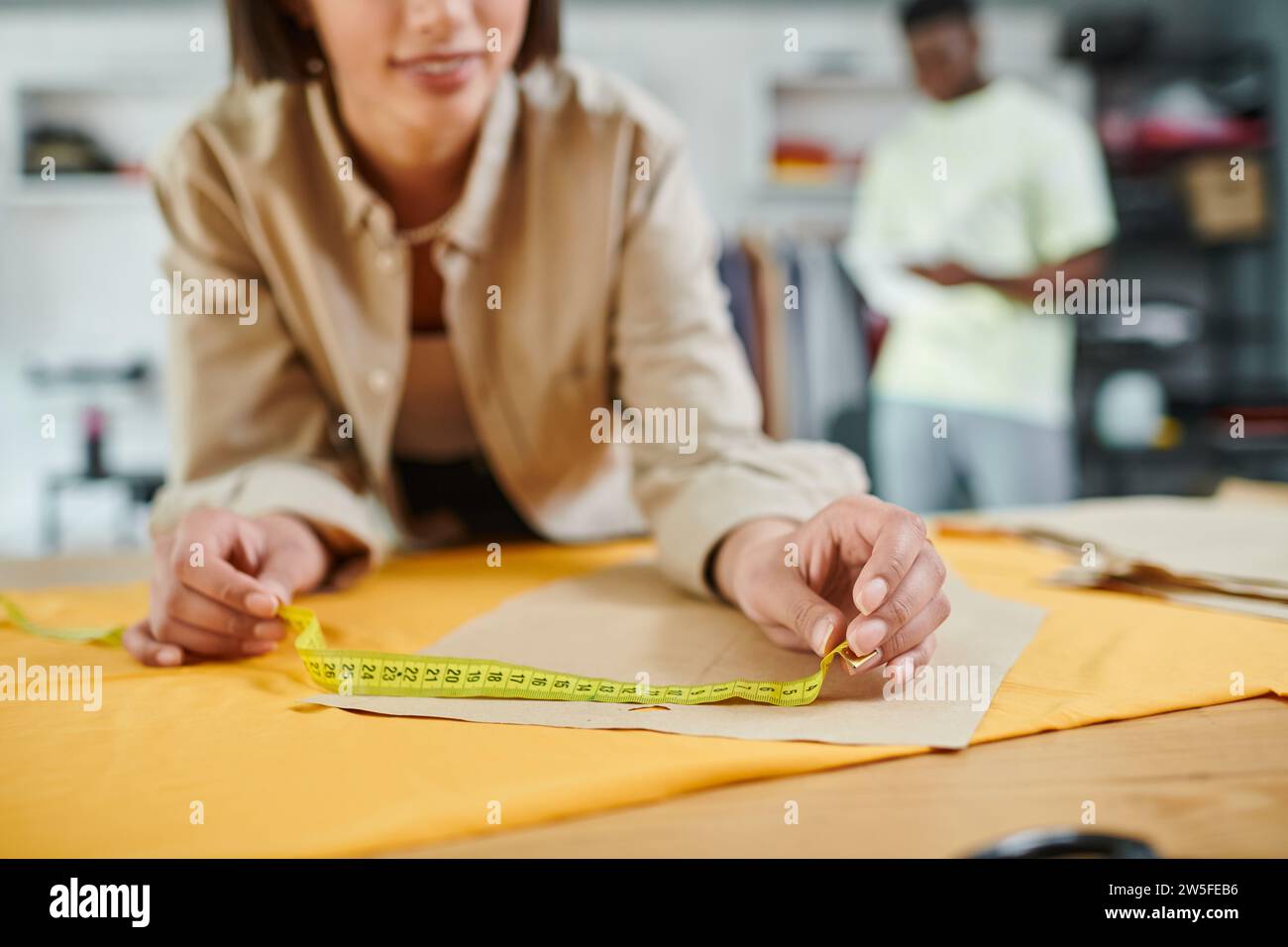 cropped view of creative designer measuring sewing pattern in print studio, small business Stock Photo