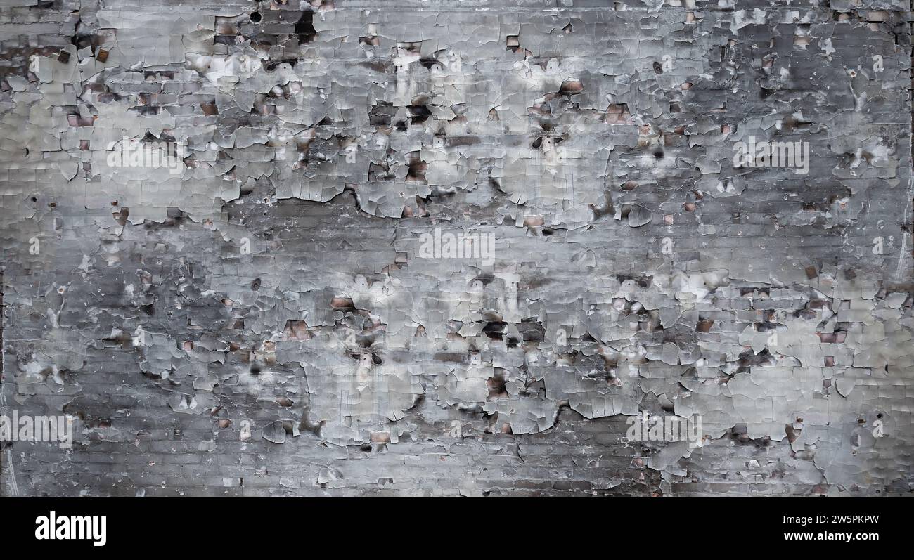 Texture of the wall with peeling paint due to fire. Irpin, Kyiv region, 2022. russia's military invasion of Ukraine. Stock Photo