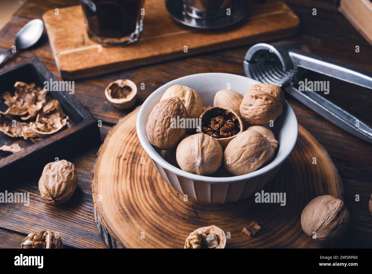 Walnuts in bowl and nutcracker on rustic table Stock Photo