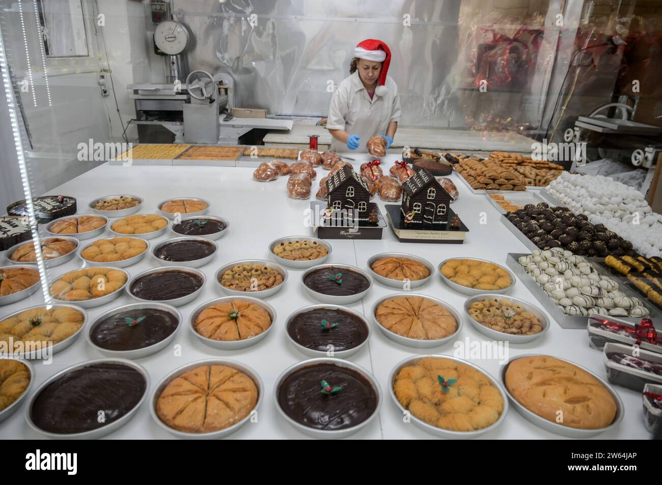 Athens, Greece. 21 December 2023. A pastry shop worker wearing a Santa