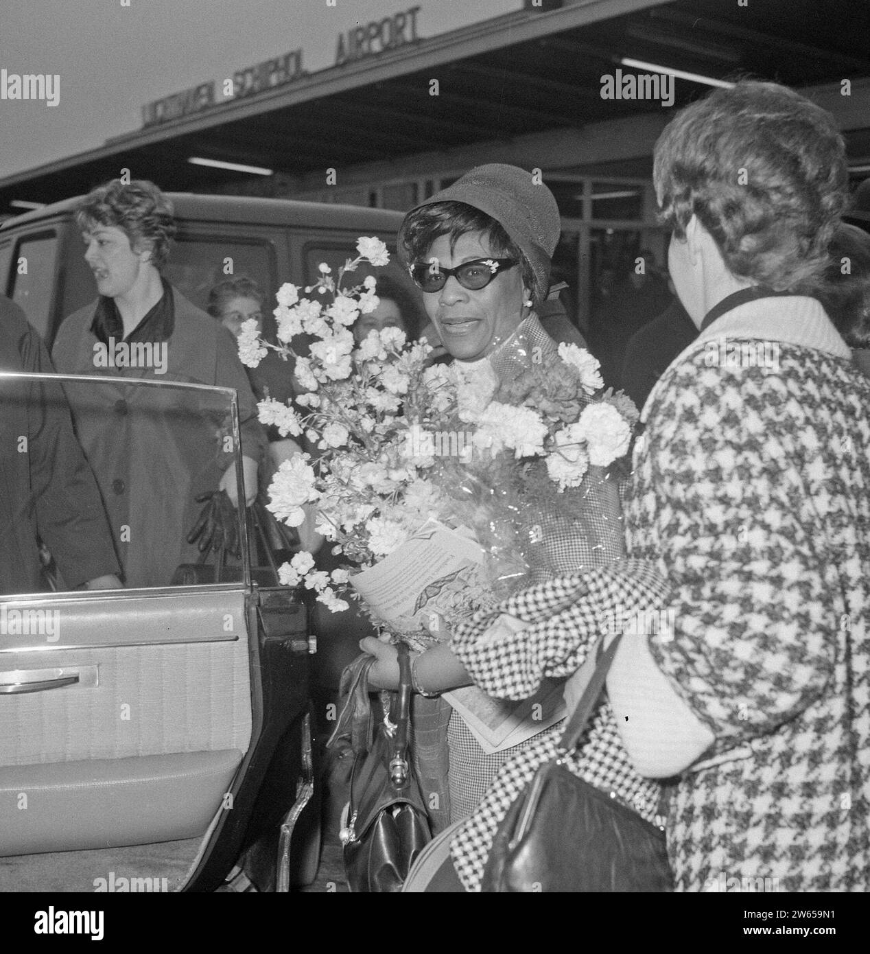 Arrival Ella Fitzgerald and Oscar Peterson at Schiphol. Ella Fitzgerald with flowers ca. April 24, 1964 Stock Photo