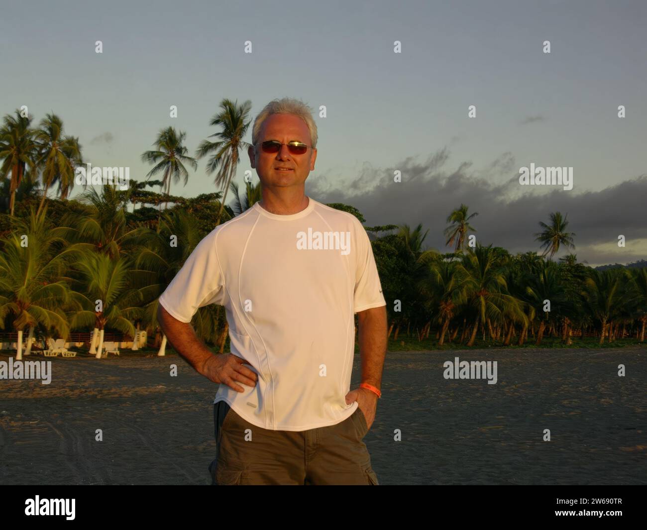 Portrait of a smiling man wearing sunglasses standing on a beach on West Coast of Costa Rica Stock Photo