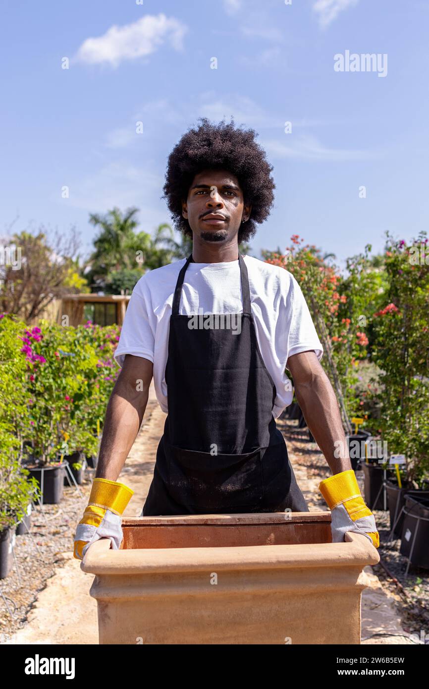 Free Photo  Smiling young gardener afro-american guy wearing gardening hat  with gloves showing peace gesture isolated on blue wall