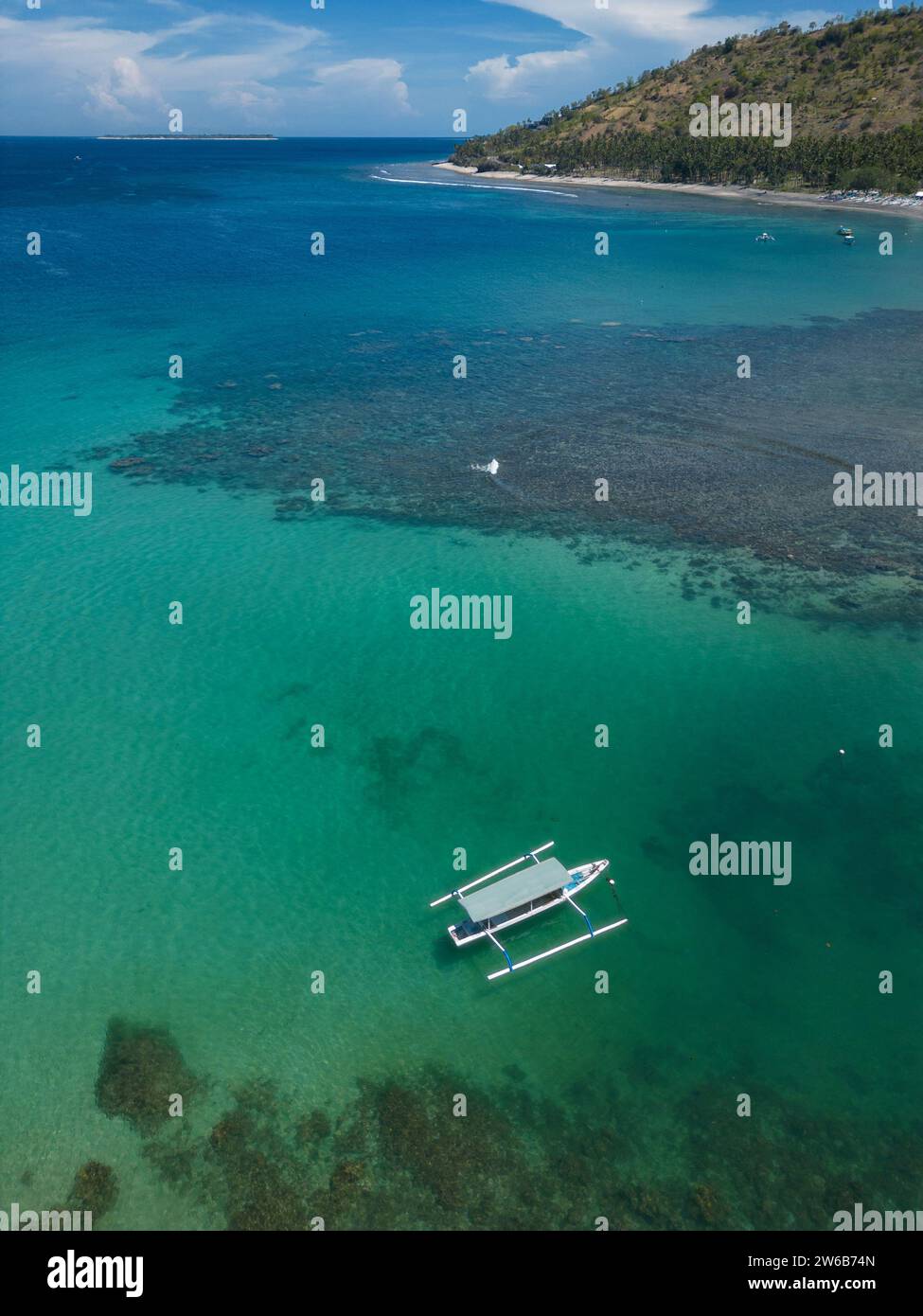 Aerial view of a traditional jukung boat anchored in Indian Ocean at Senggigi beach, Lombok, Indonesia Stock Photo