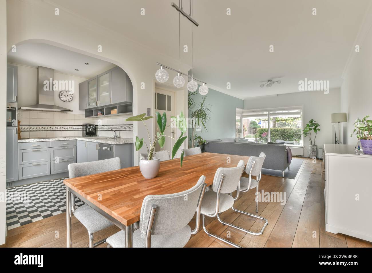 Wooden table and chairs in dining room of modern house with living room ...
