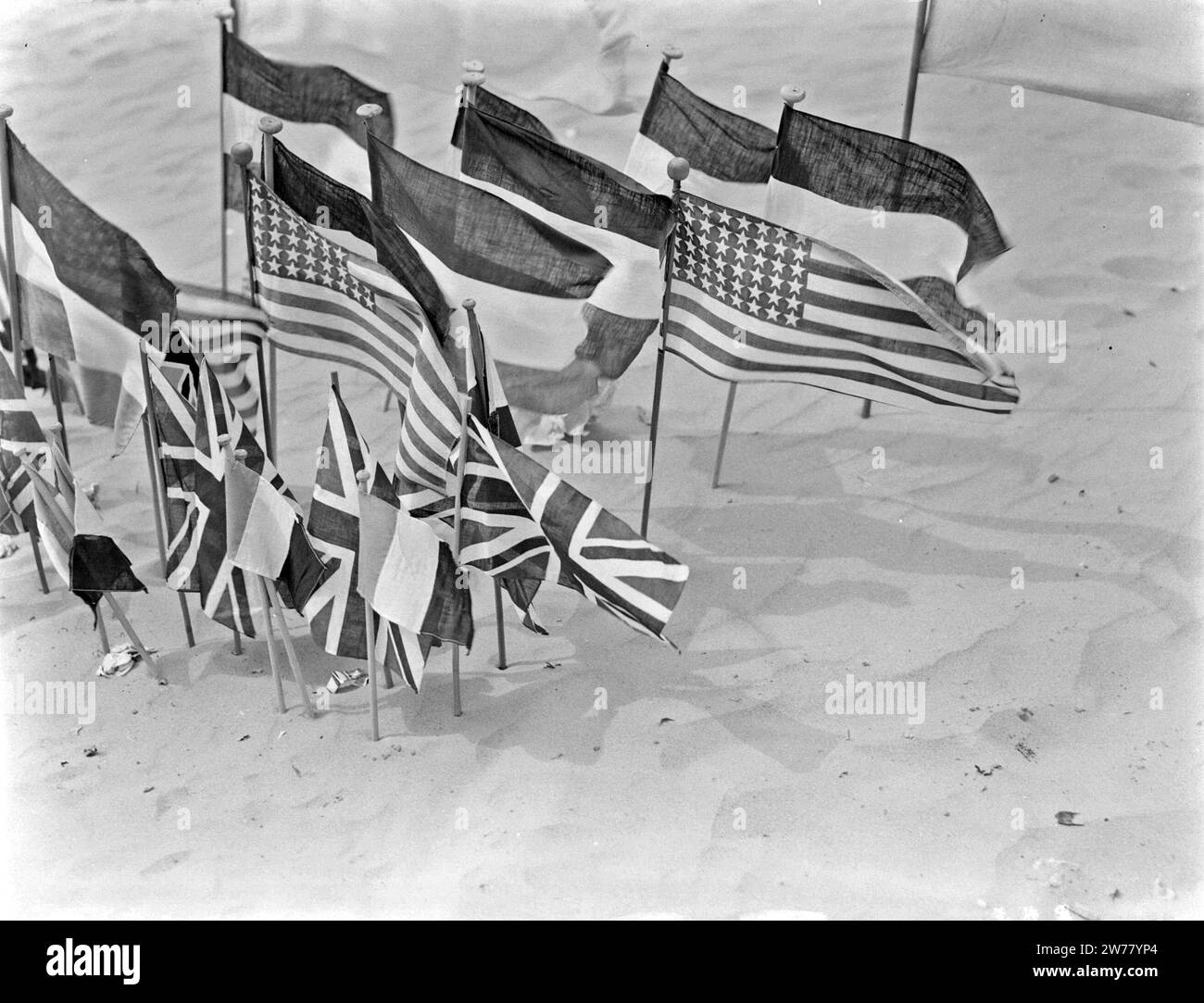 Miniature flags of different nations in the sand ca. undated Stock Photo