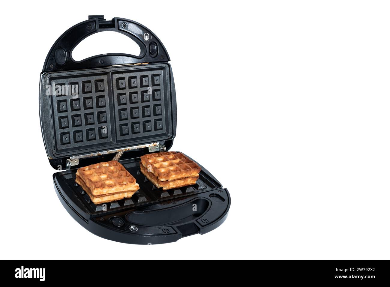 Waffles in an electric waffle iron on a white background. Homemade
