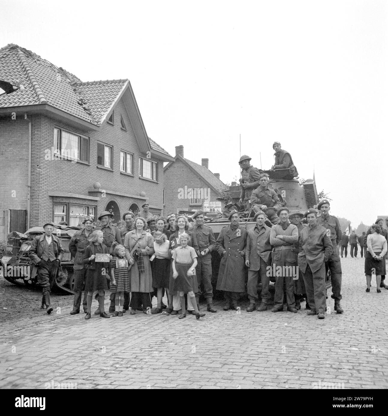 Inhabitants of Aalst posing with soldiers of the Irish Guards,the children have British and American flags made of paper ca. September 18, 1944 Stock Photo