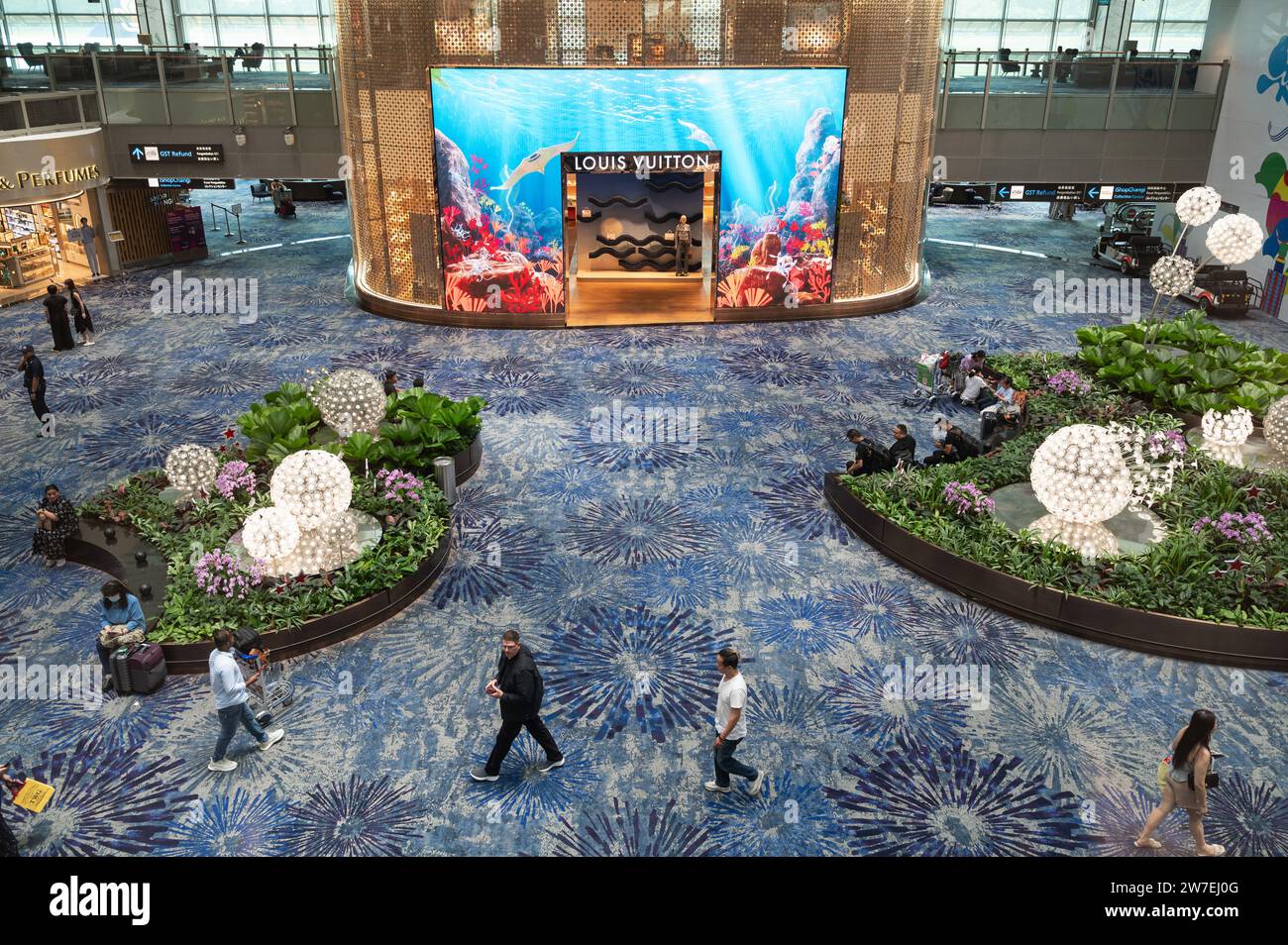 31.07.2023, Singapore, Singapur,  - Interior view of the modern Terminal 3 with air travellers at Singapore Changi Airport. A duty-free shop of the lu Stock Photo