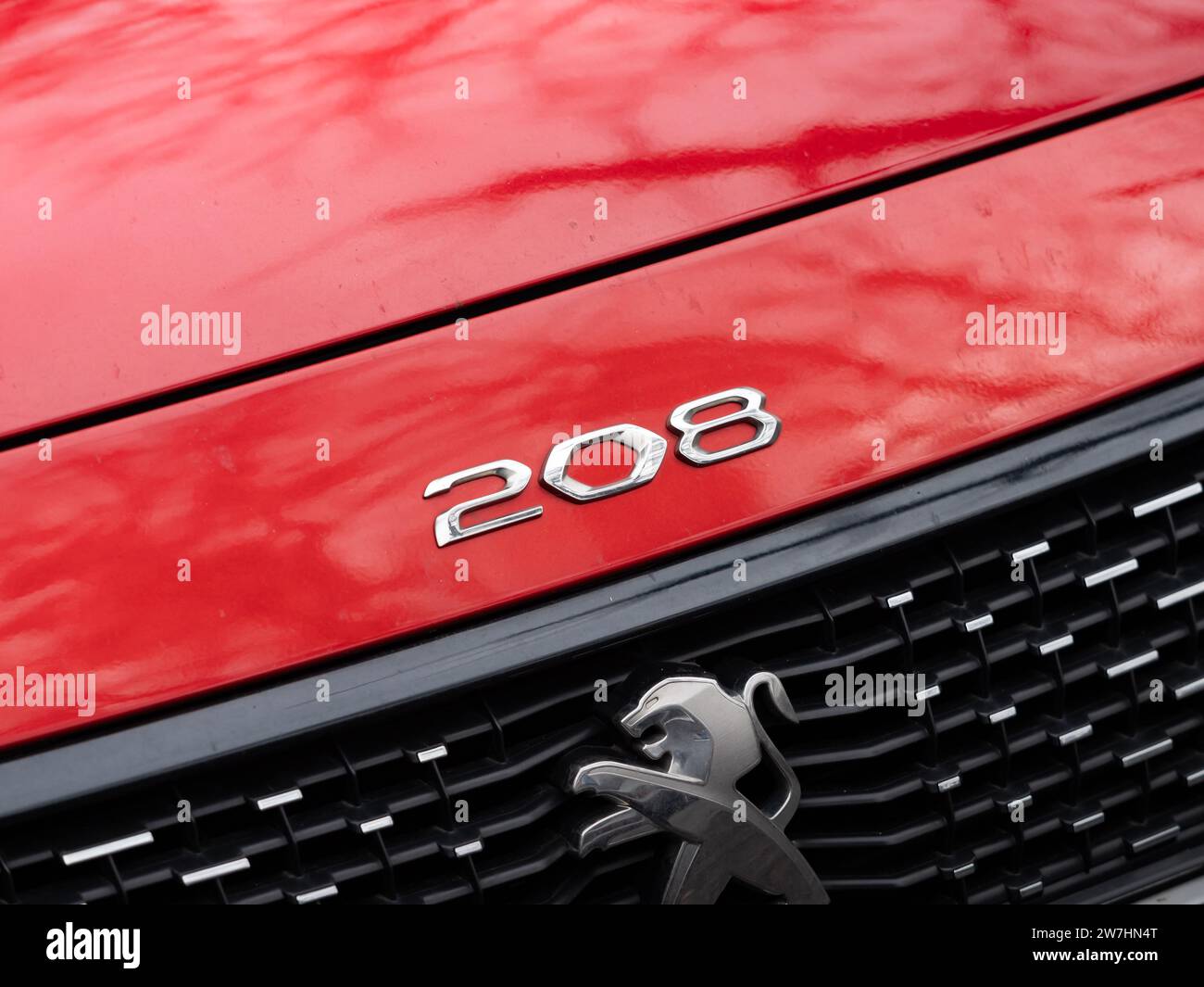 Peugeot 208 emblem of the French car brand. Close up of the hood with the icon on the exterior. Logo sign on the red color at the front. Stock Photo