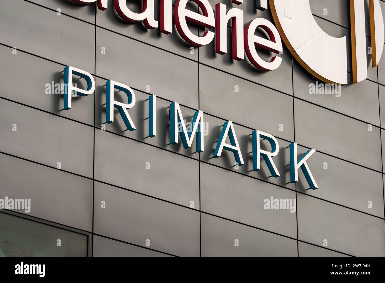 Primark logo sign of the fast fashion company. The retailer of clothes and accessories is located in a shopping mall. Advertisement on the building. Stock Photo