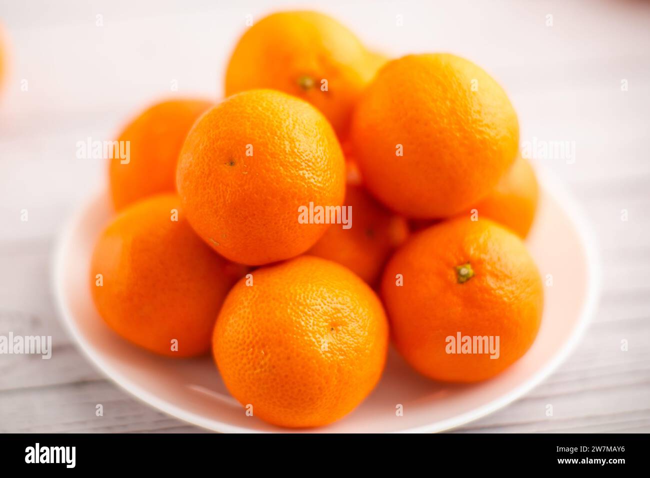 Plate of mandarins on a bright background, showcasing the nutritional