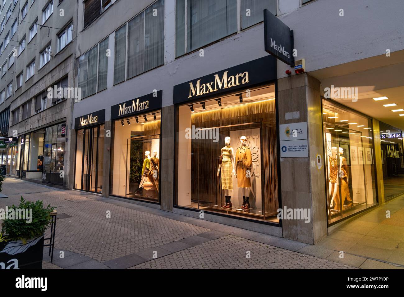 Facade of MaxMara store with lit windows with mannequins Stock Photo