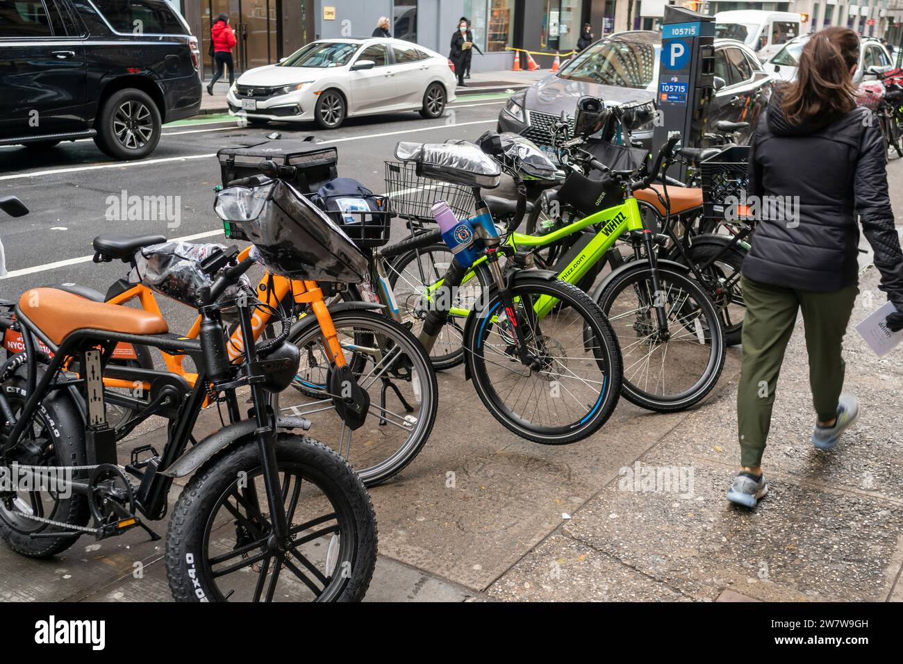 A collection of deliverymen’s e-bikes parked outside a restaurant in Chelsea in New York on Monday, December 18, 2023. (© Richard B. Levine) Stock Photo