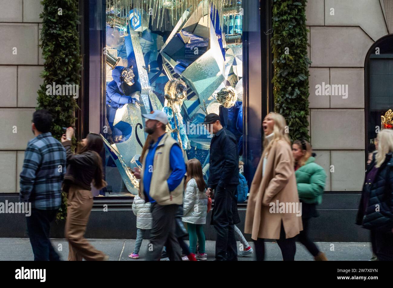 People walk past Bergdorf Goodman’s holiday windows during the last car-free Fifth Avenue in Midtown Manhattan during the Holiday Open Streets on Sunday, December 17, 2023. New York City closed a nine-block stretch of Fifth Avenue in Midtown to vehicles on Sundays in December creating a holiday block party for visitors. (© Richard B. Levine) Stock Photo