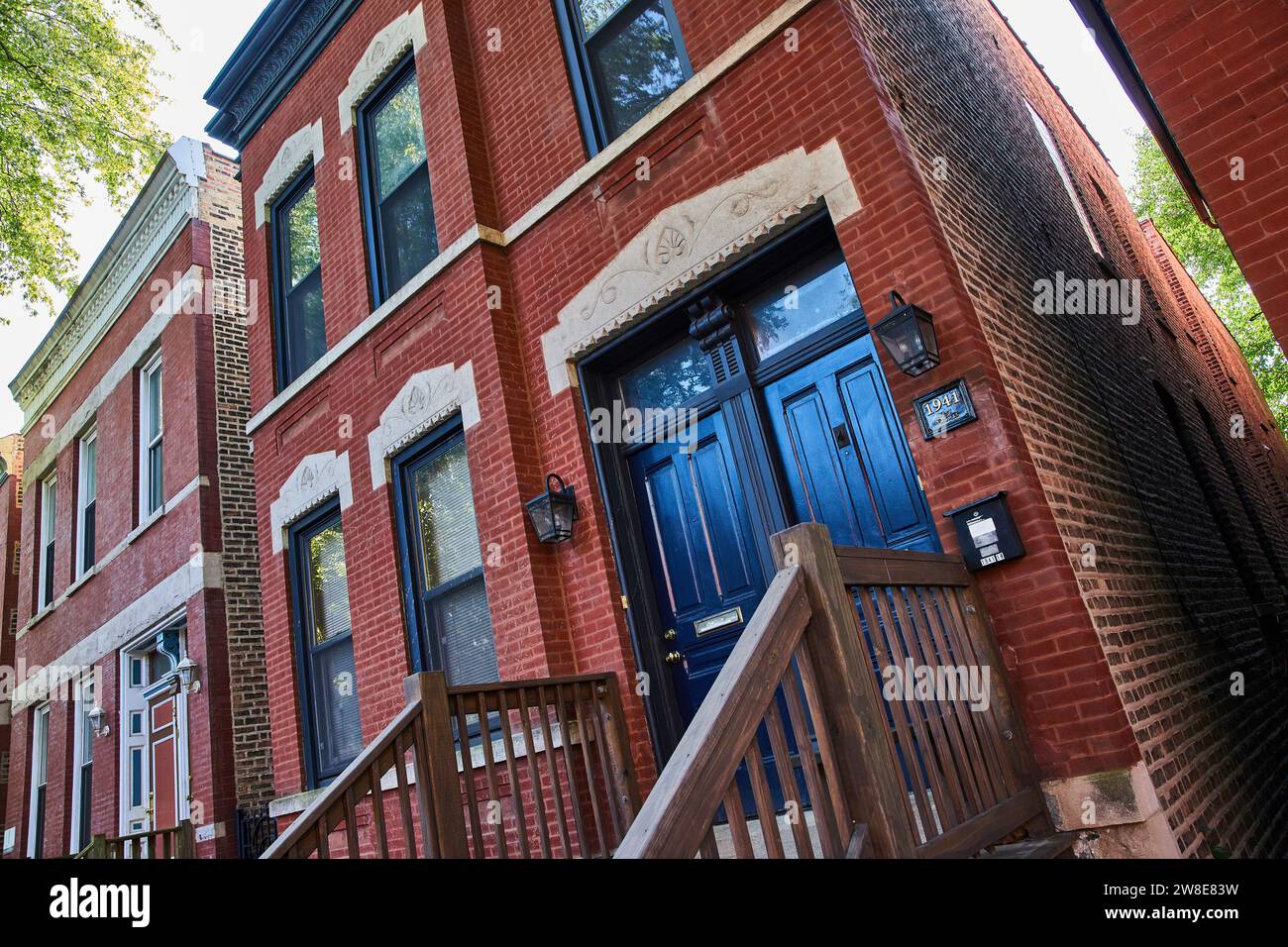 Tilted view of old red brick house with black doors, ominous, haunted, evil, finance, mortgage