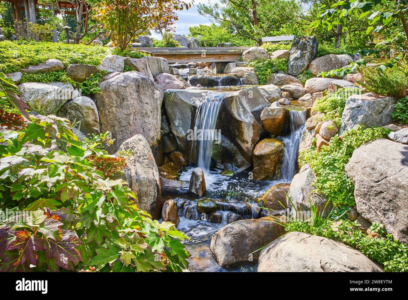 Tranquil Waterfall Garden with Lush Greenery and Rocks Stock Photo