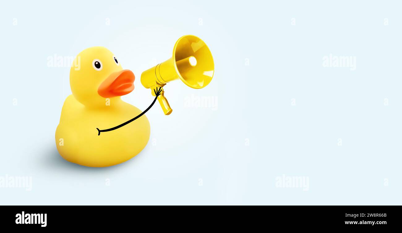 Creative Funny Yellow Duck Holding A Loudspeaker On A Blue Background. Yellow Press And News, Concept. Marketing, Creative Idea. Driving Traffic And A Stock Photo