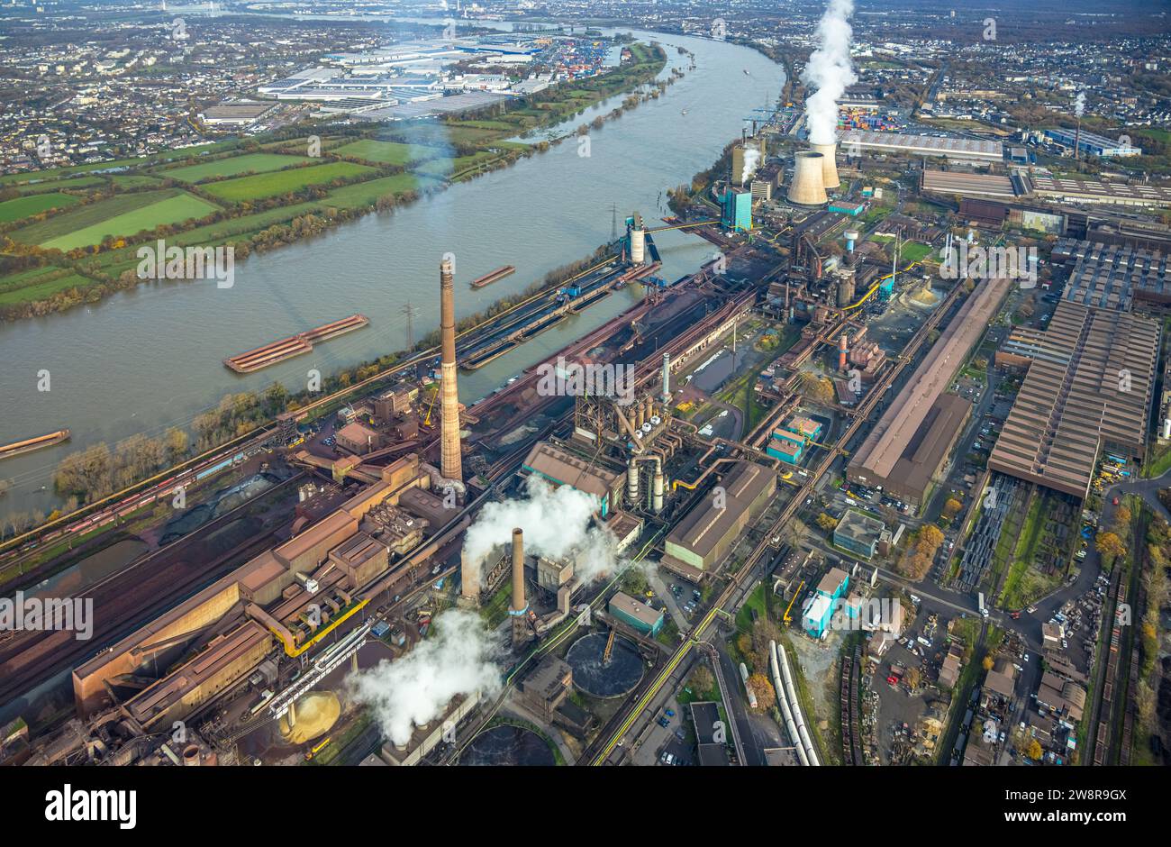 Aerial view, Hüttenwerke Krupp Mannesmann HKM and gas-fired power plant Huckingen with smoking cooling towers at the river Rhine, surrounded by autumn Stock Photo