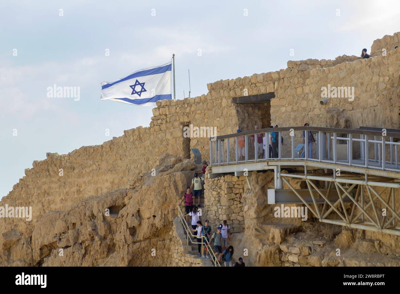 November 2022, The israeli flag flies proudly as tourists visit Massada, built by Herod the Great, and the ancient site of Jewish revolt against the R Stock Photo