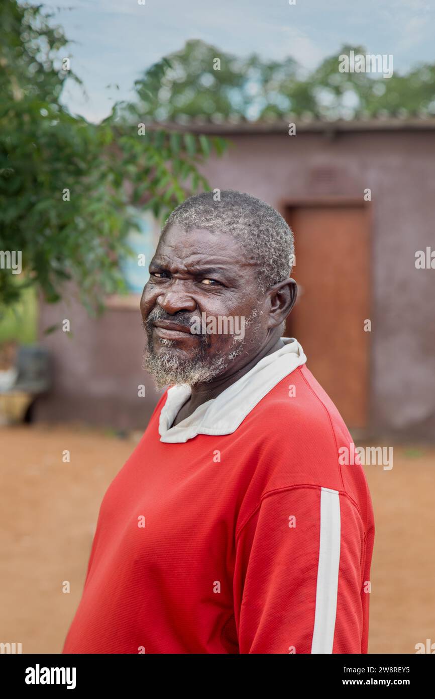 old african man in the village standing in the yard in front of the house Stock Photo