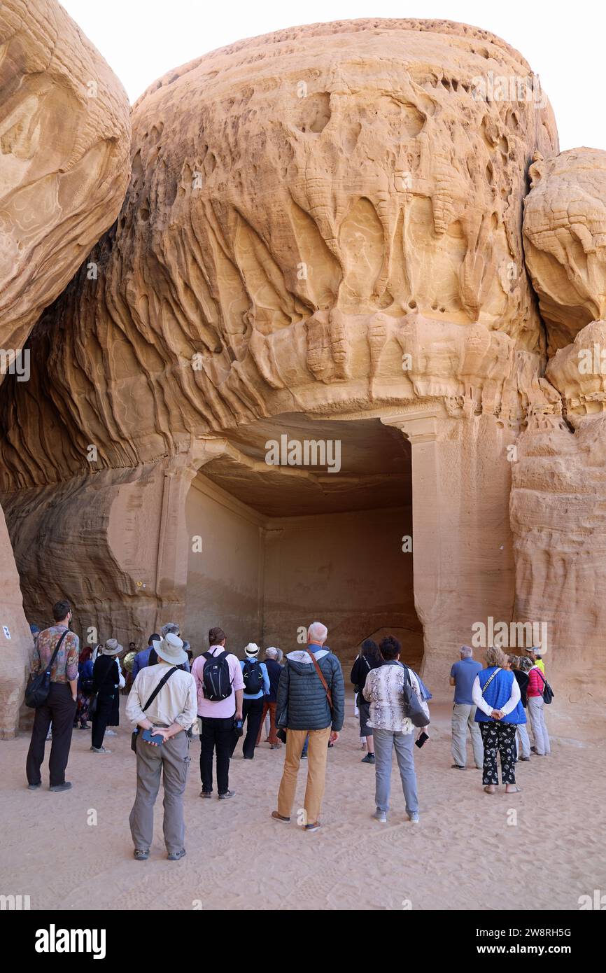 Tourists at the Diwan at Jabal Ithlib on the tour of Hegra in Saudi Arabia Stock Photo