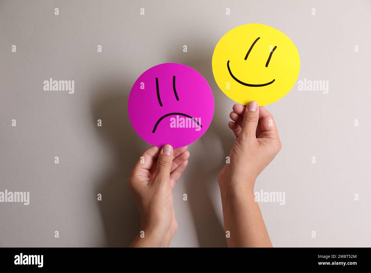 Choice concept. Woman holding papers with sad and happy emoticons on ...