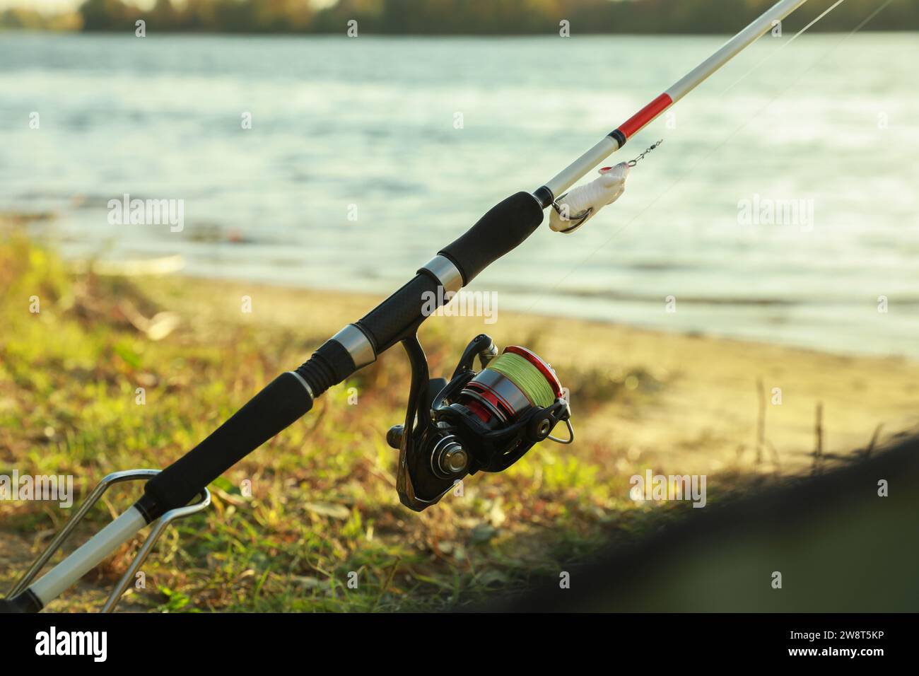 Fishing rod with reel at riverside on sunny day Stock Photo - Alamy