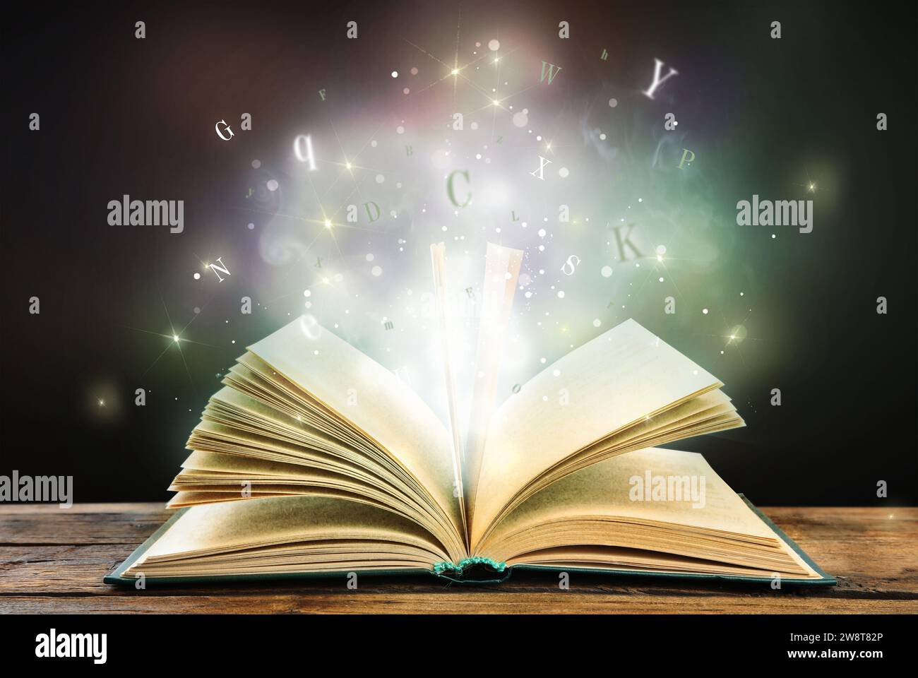 Open book with magic light and glowing letters flying out of it on ...