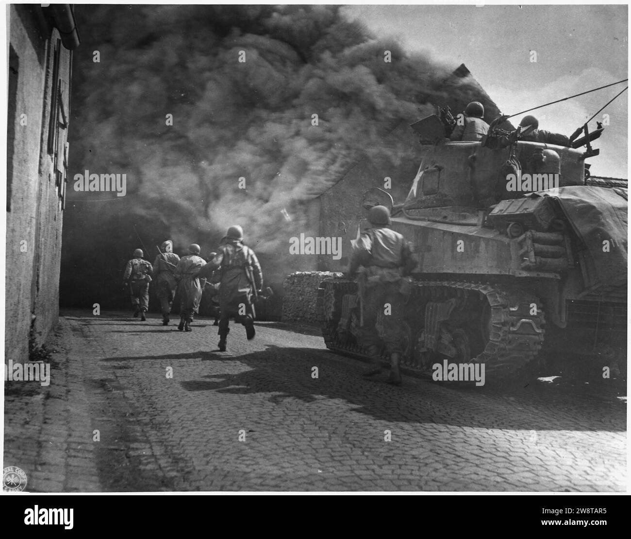WWII, Europe, Germany, ''U.S. Third Army iruns throuhg smoke filled streets in Wernberg'' Stock Photo