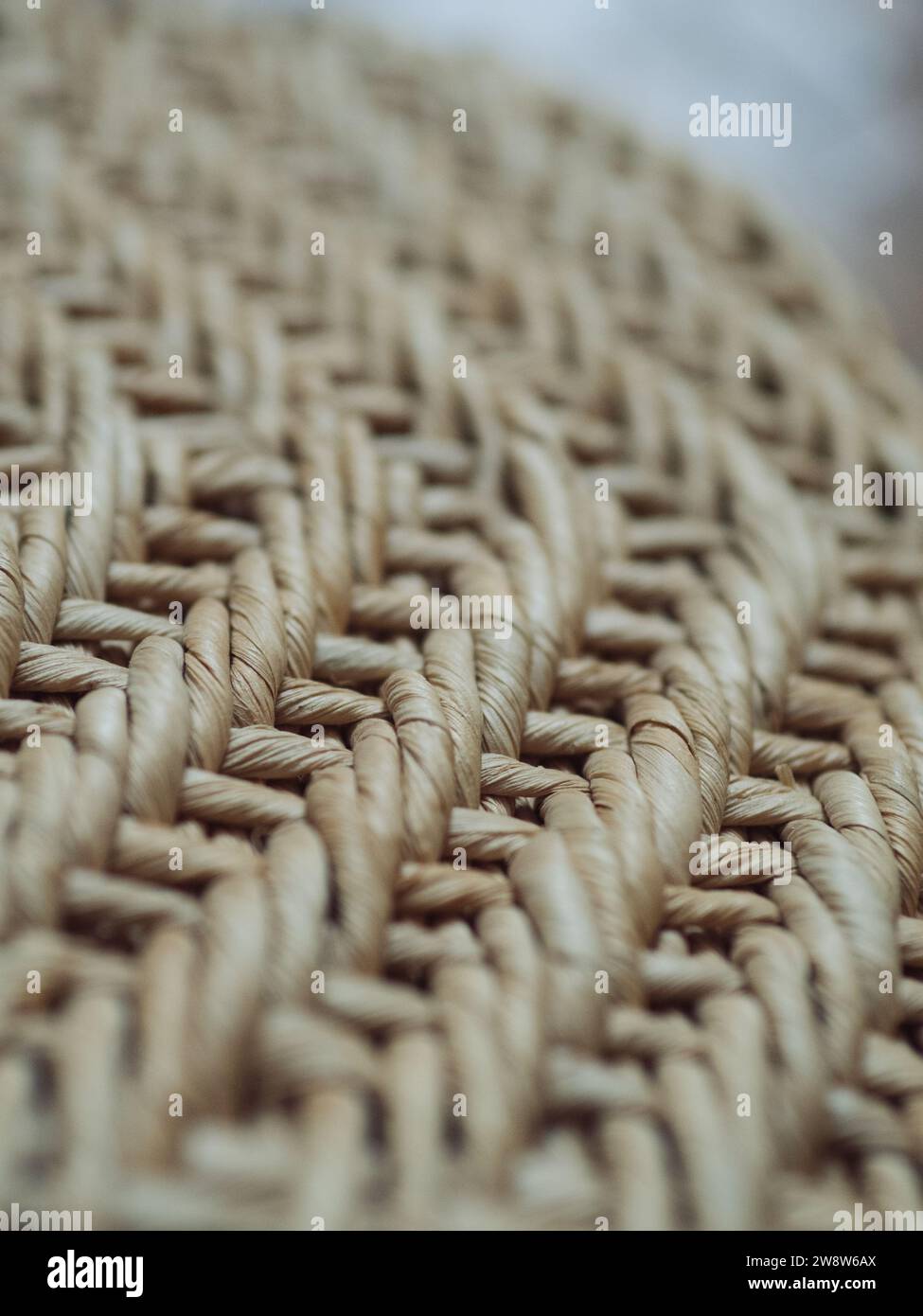 Vertical close up image of a straw shoulder beach bag detail. Stock Photo