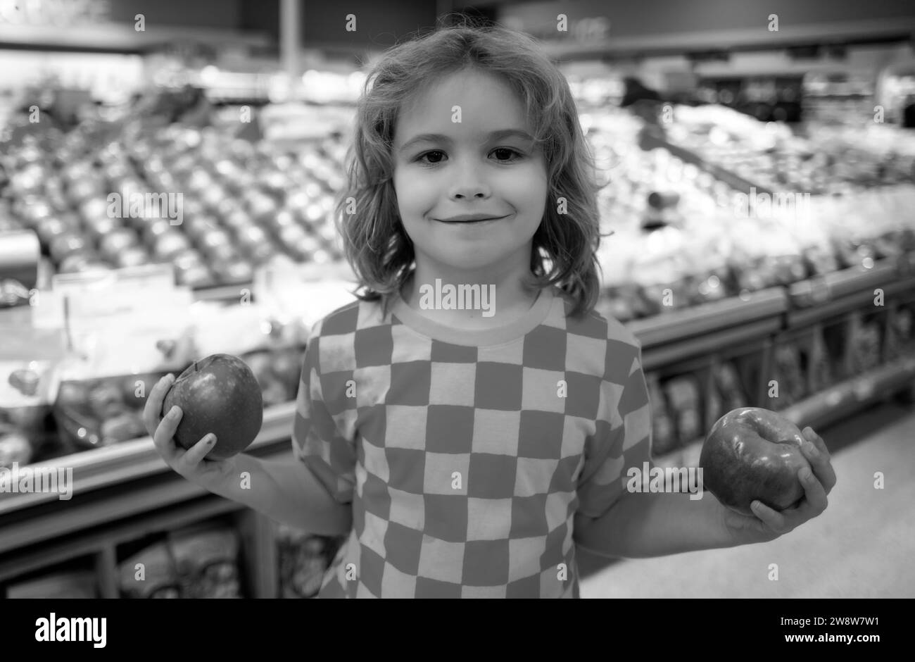 Child hold apple fruits at grocery store. Portrait of child in a food