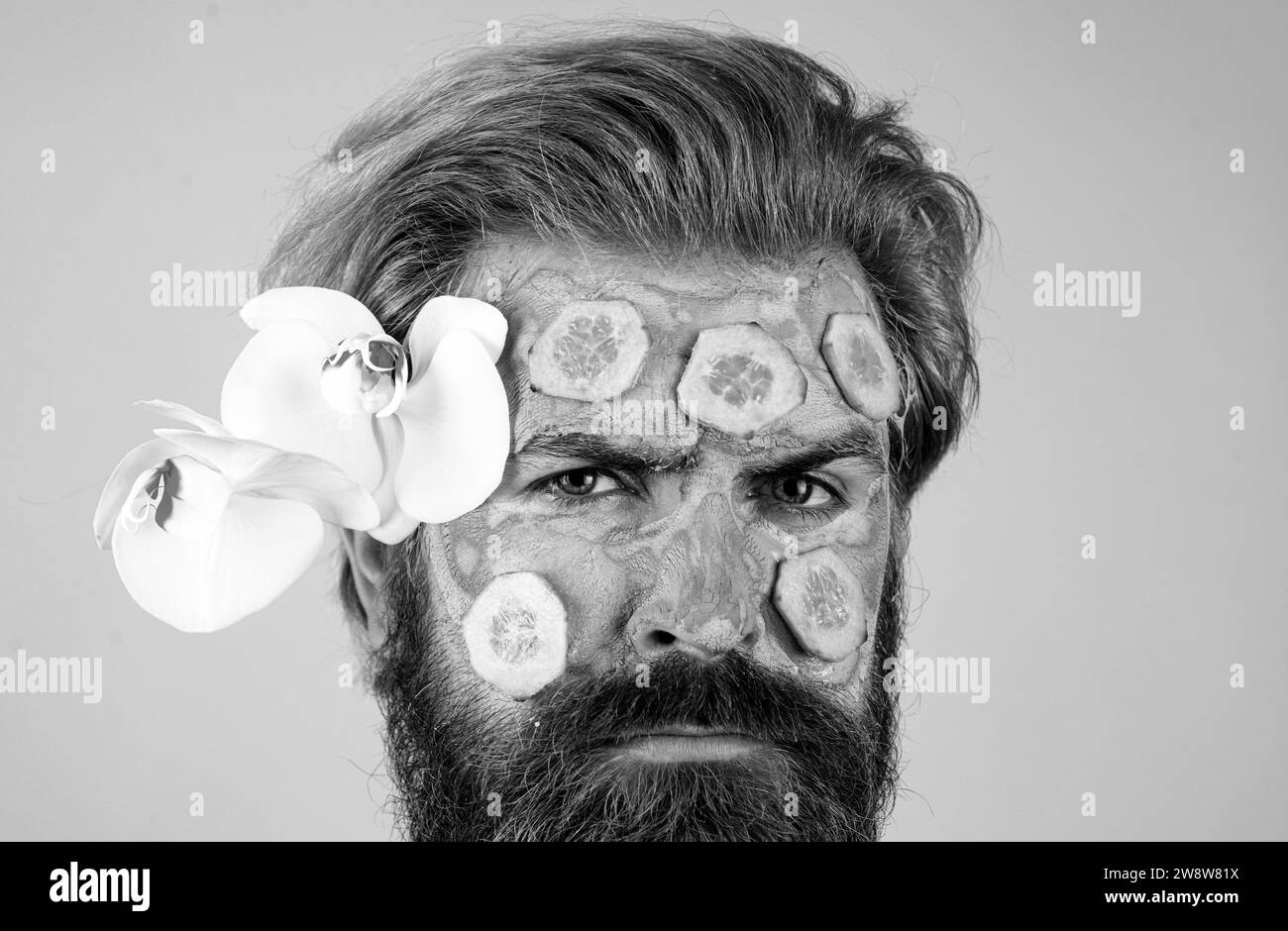 Close up face with clay mask and cucumber slices. Spa, dermatology
