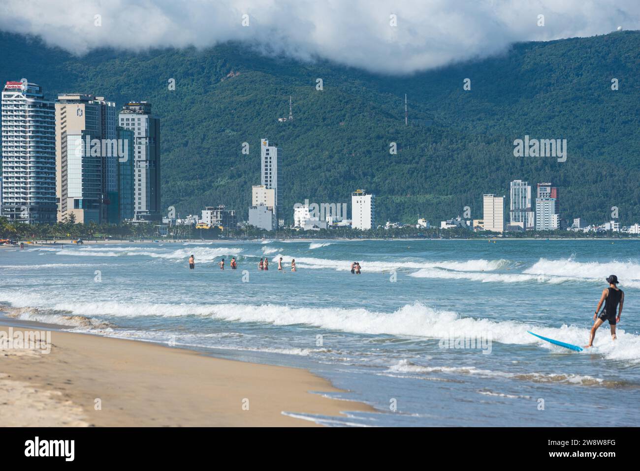 Da Nang, Vietnam - October 4, 2023: beach with swimmers and row of modern hotels in distance. Stock Photo