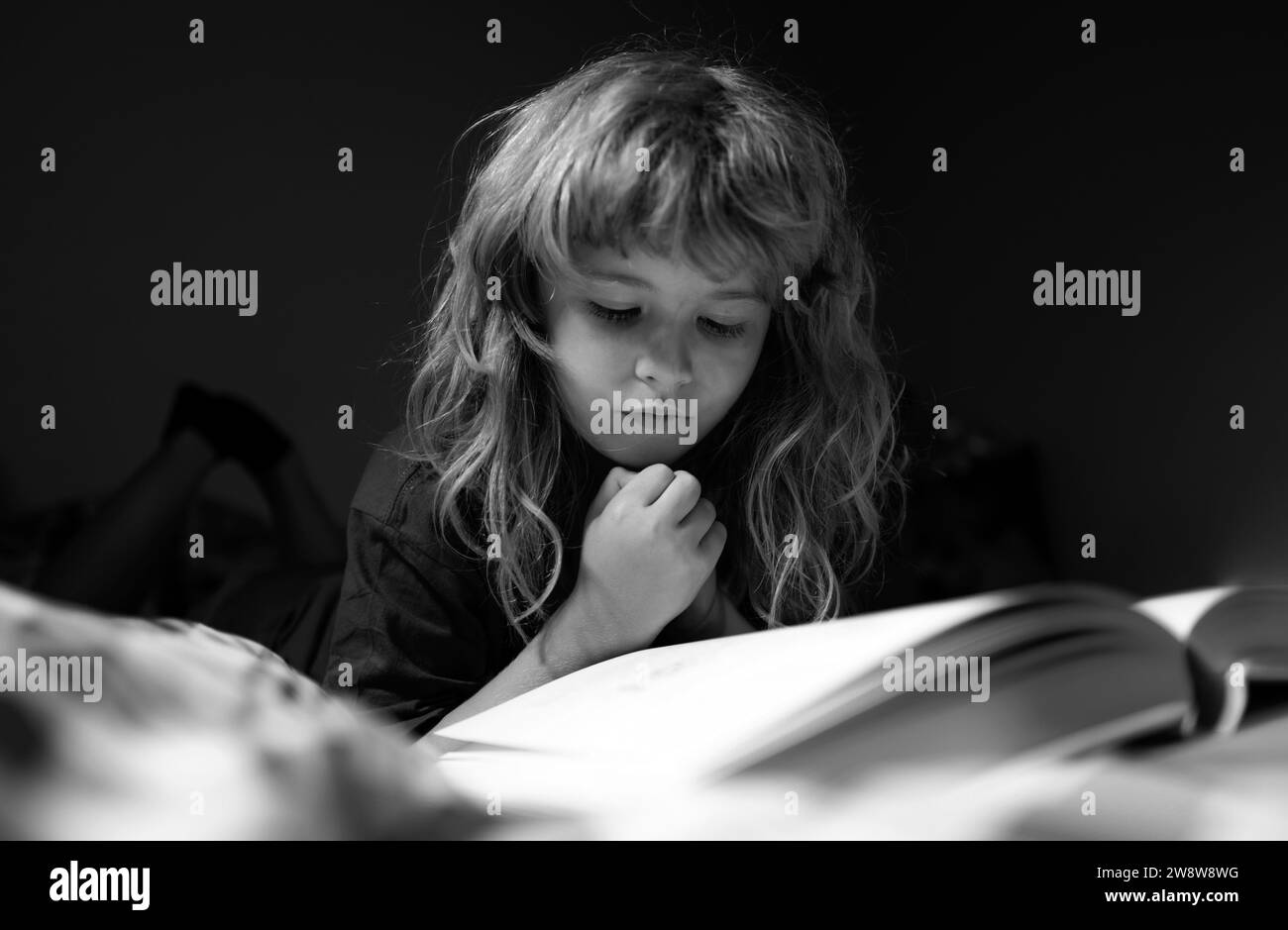 Child boy reading book. Kids reading story. Kids face with night light