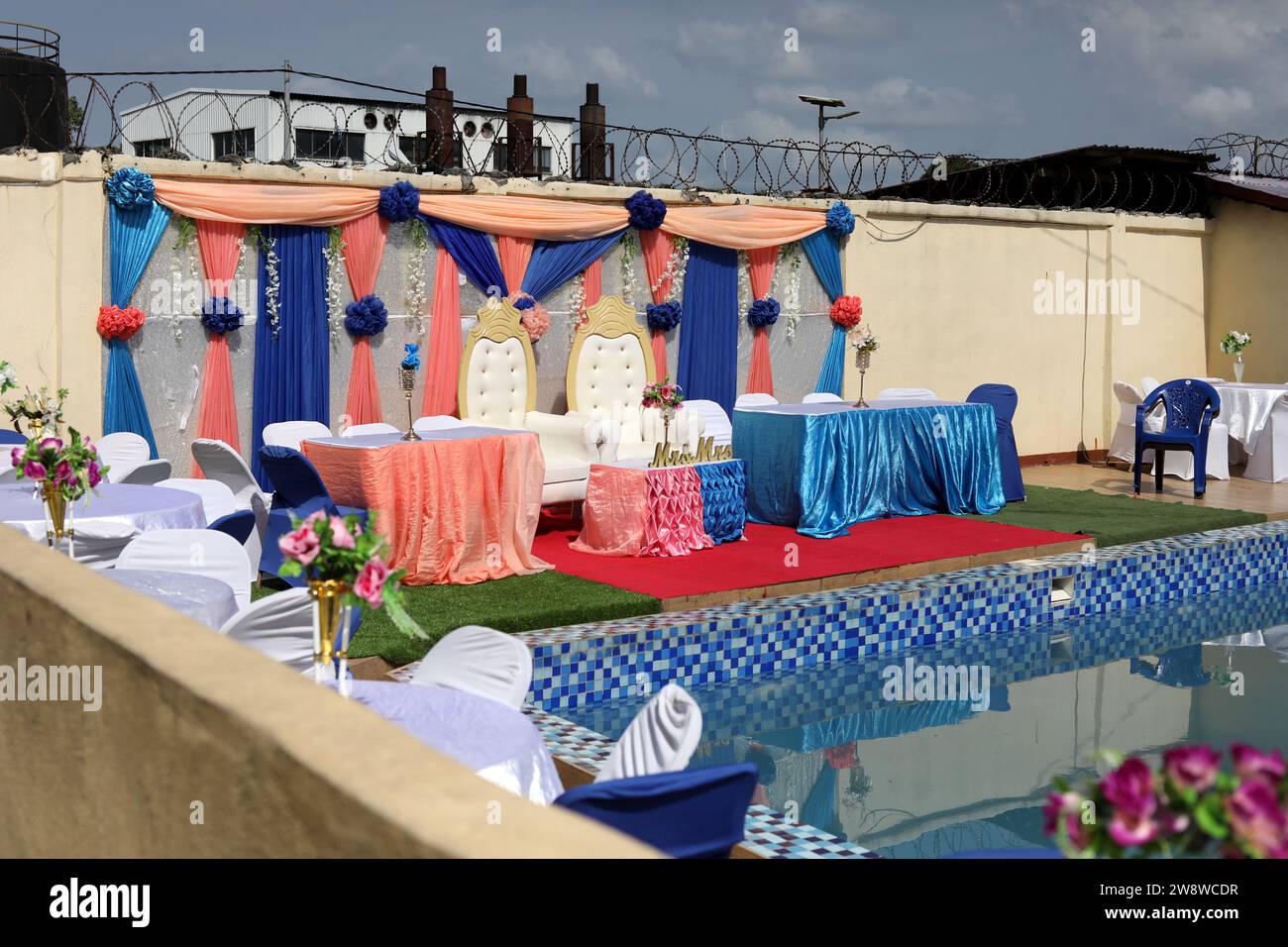 Colourful wedding breakfast party set-up by a pool on a wedding day in Freetown, Sierra Leone, Africa. Stock Photo