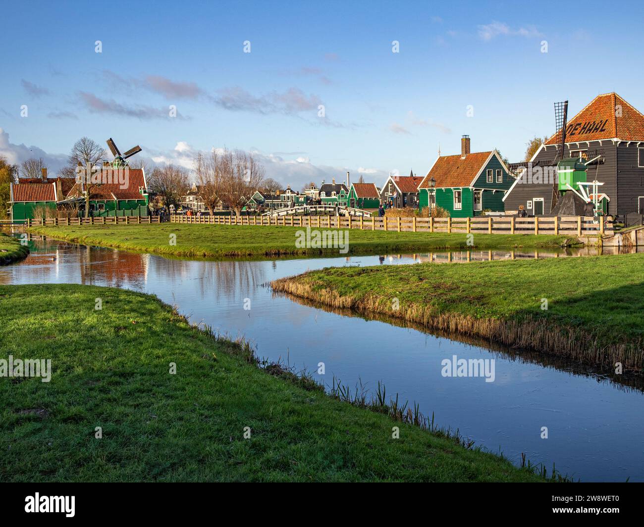 Traditional Dutch houses with windmills, wooden drawbridge and the cheese farm De Hall at the open air museum of Zaanse Schans, Zaandam / Zaandijk, Ne Stock Photo