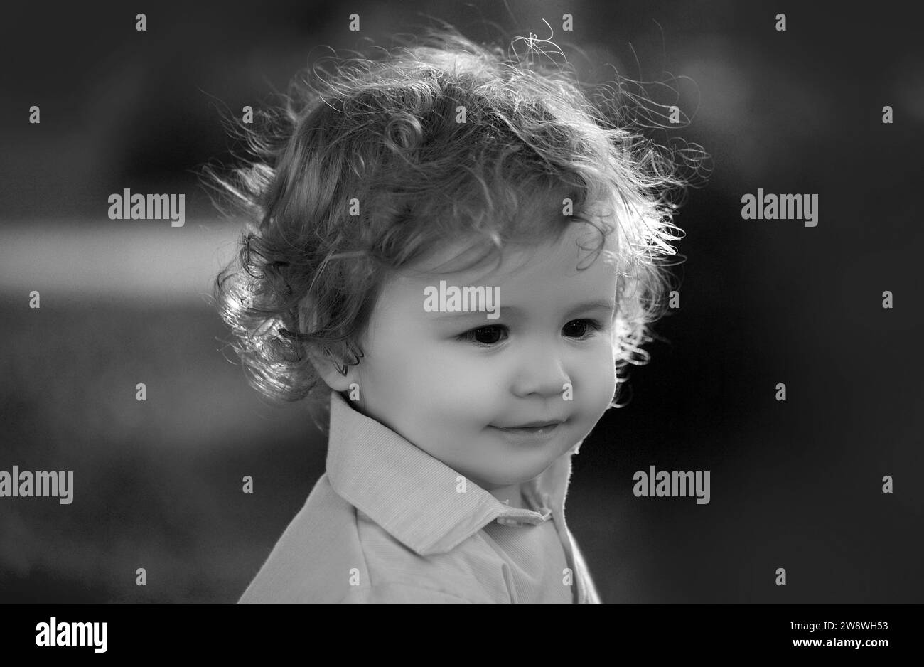 Baby playing in green grass. Baby face closeup. Funny little child