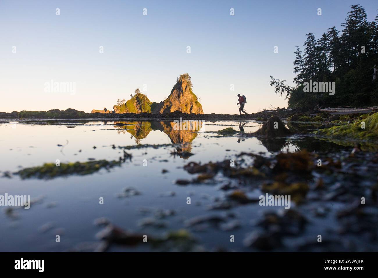 Reflection of distant backpacker hiking Pacific Northwest Trail Stock Photo
