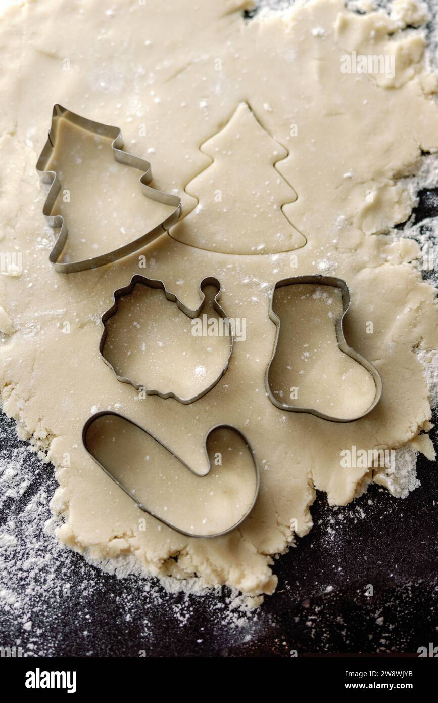 Cutting christmas shapes into cookie dough Stock Photo