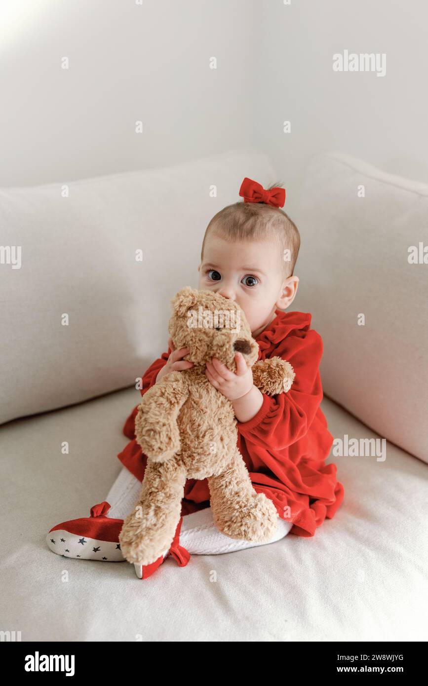 Infant in red with teddy for christmas Stock Photo