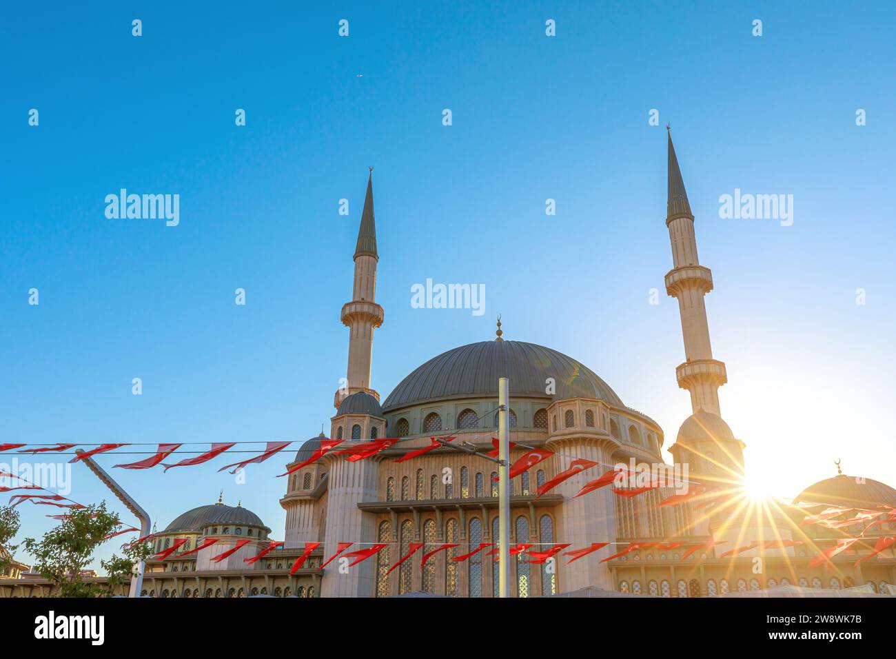 journey around Taksim Mosque in Istanbul with Turkish flags captures its modern beauty at sunset. Stock Photo