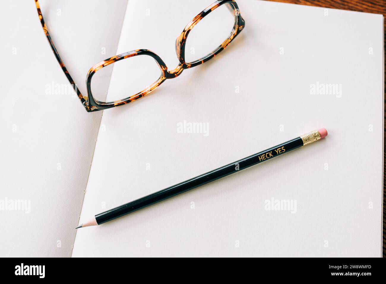 Glasses Resting on an Open Book with a Pencil Stock Photo