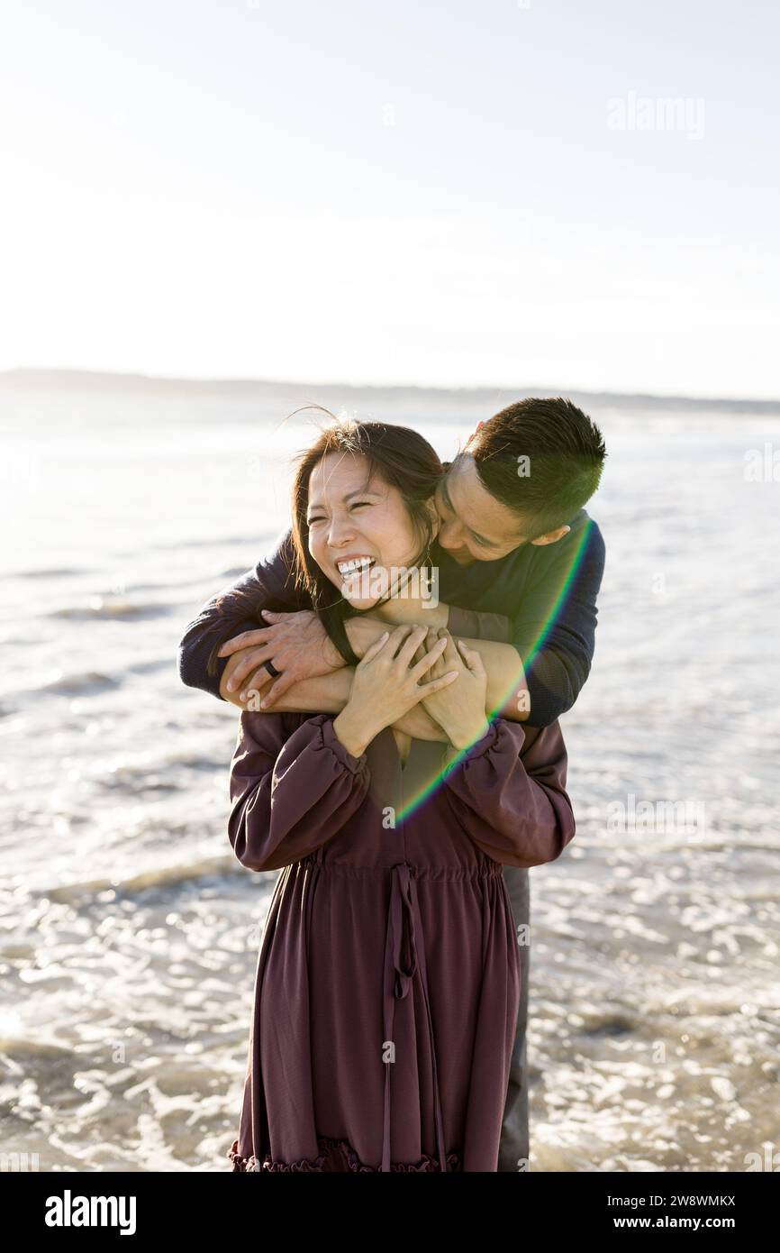 Asian Couple Posing on Beach at Sunset in San Diego Stock Photo