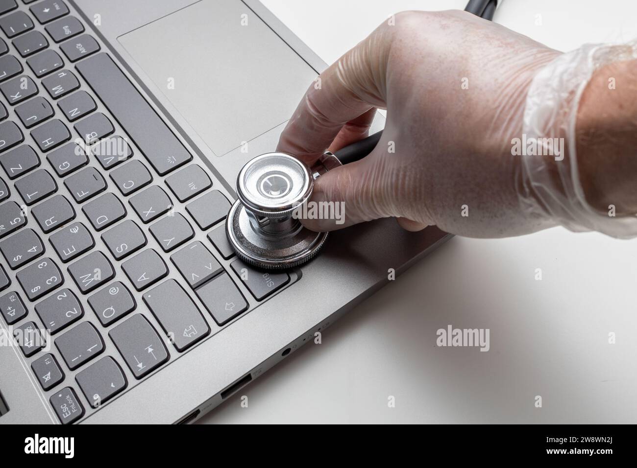 Hand with stethoscope on laptop, closeup. Concept of technical s Stock Photo