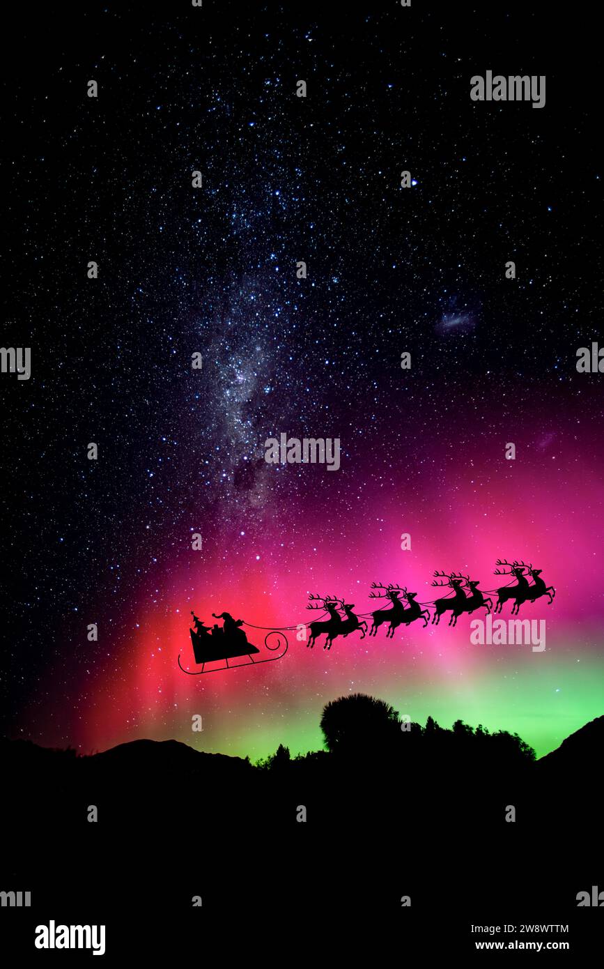 Santa crossing the night sky over Fiordland national park with the Aurora Australis and Milky way, South Island, New Zealand. Stock Photo
