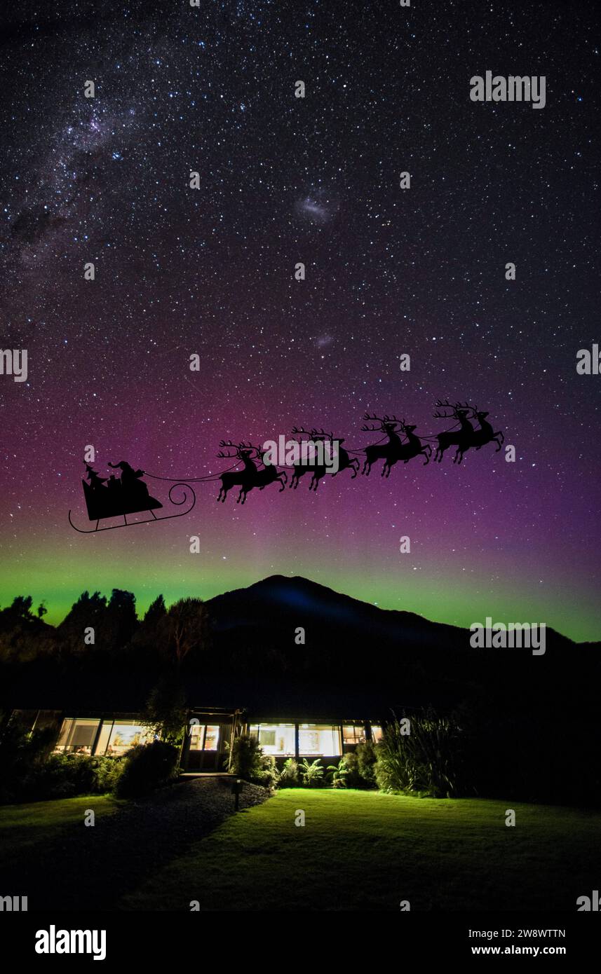 Santa crossing the night sky over Fiordland national park with the Aurora Australis and Milky way, South Island, New Zealand. Stock Photo