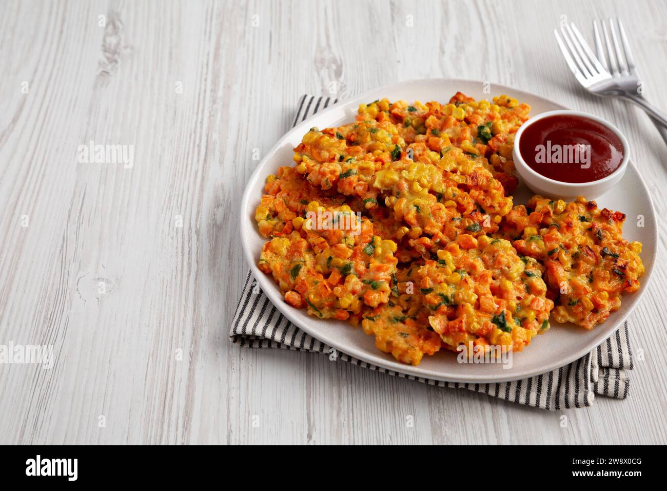 Homemade Carrot Corn Fritters with Ketchup on a Plate, side view. Copy